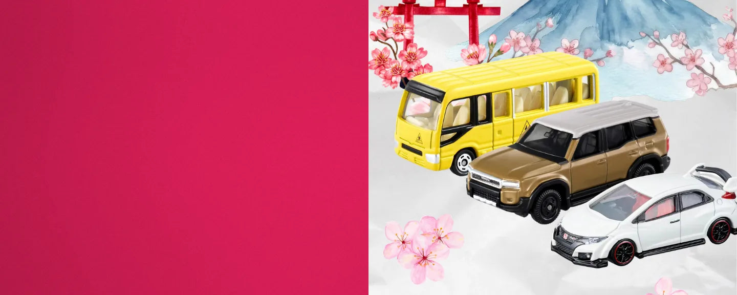 Tomica yellow bus, gold Toyota SUV and white Honda Civic diecast cars with Mount Fuji, a red torii gate and cherry blossoms.