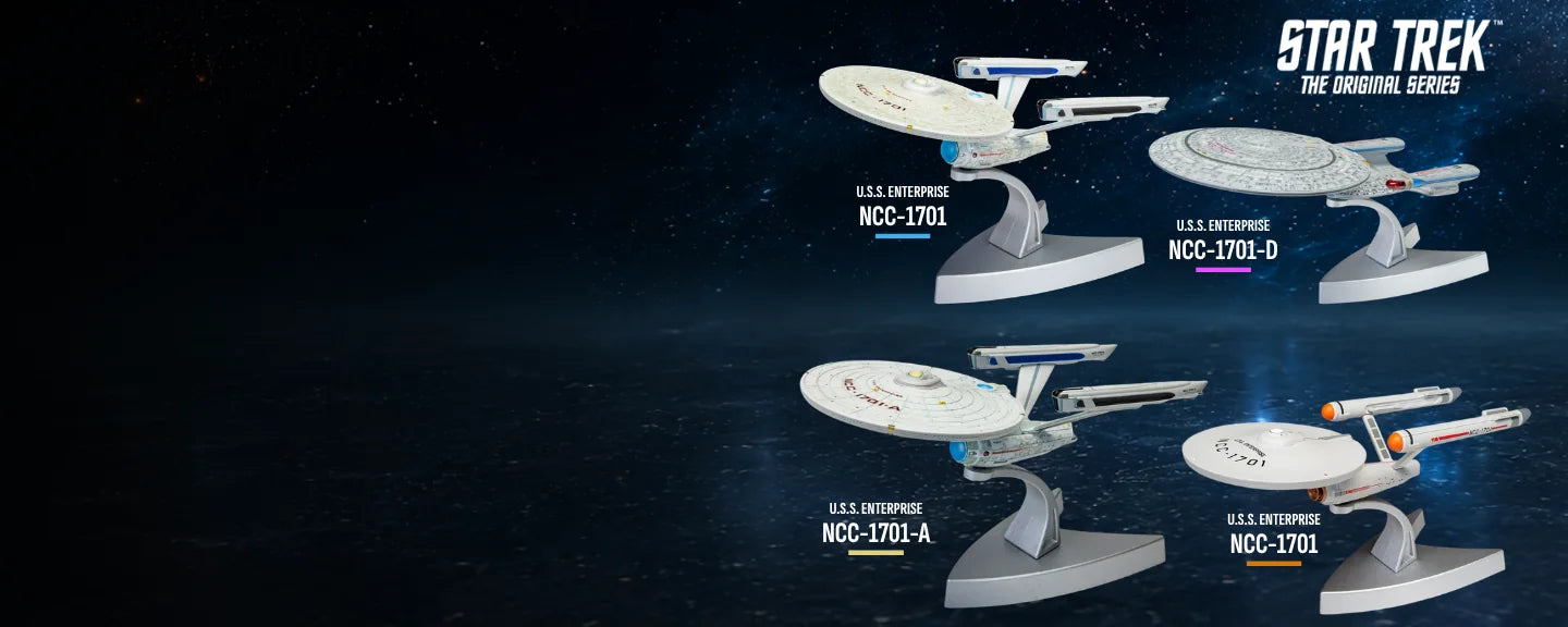 Four Corgi Star Trek Enterprise models against a star field.